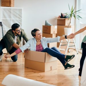Happy parents and daughter having fun while moving into a new home.